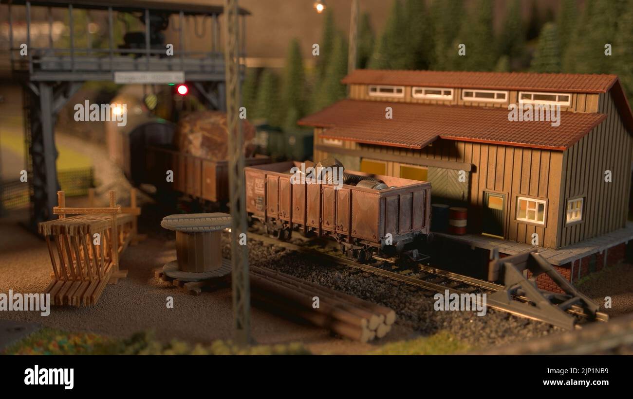 Model freight train arriving at railway station. Miniature railway