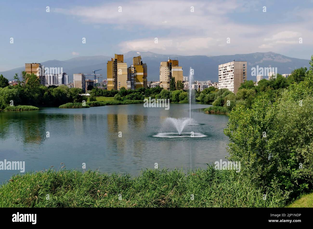 Spring panorama of a part of a residential area with a lake and a fountain,  Drujba, Sofia, Bulgaria Stock Photo