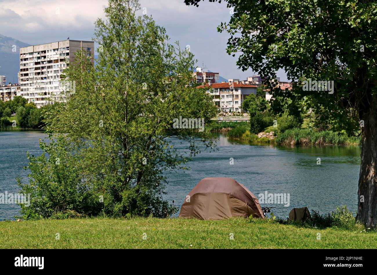 Early spring with fresh trees and a meadow with a tent on the shore of the lake in residential district Drujba, Sofia, Bulgaria Stock Photo