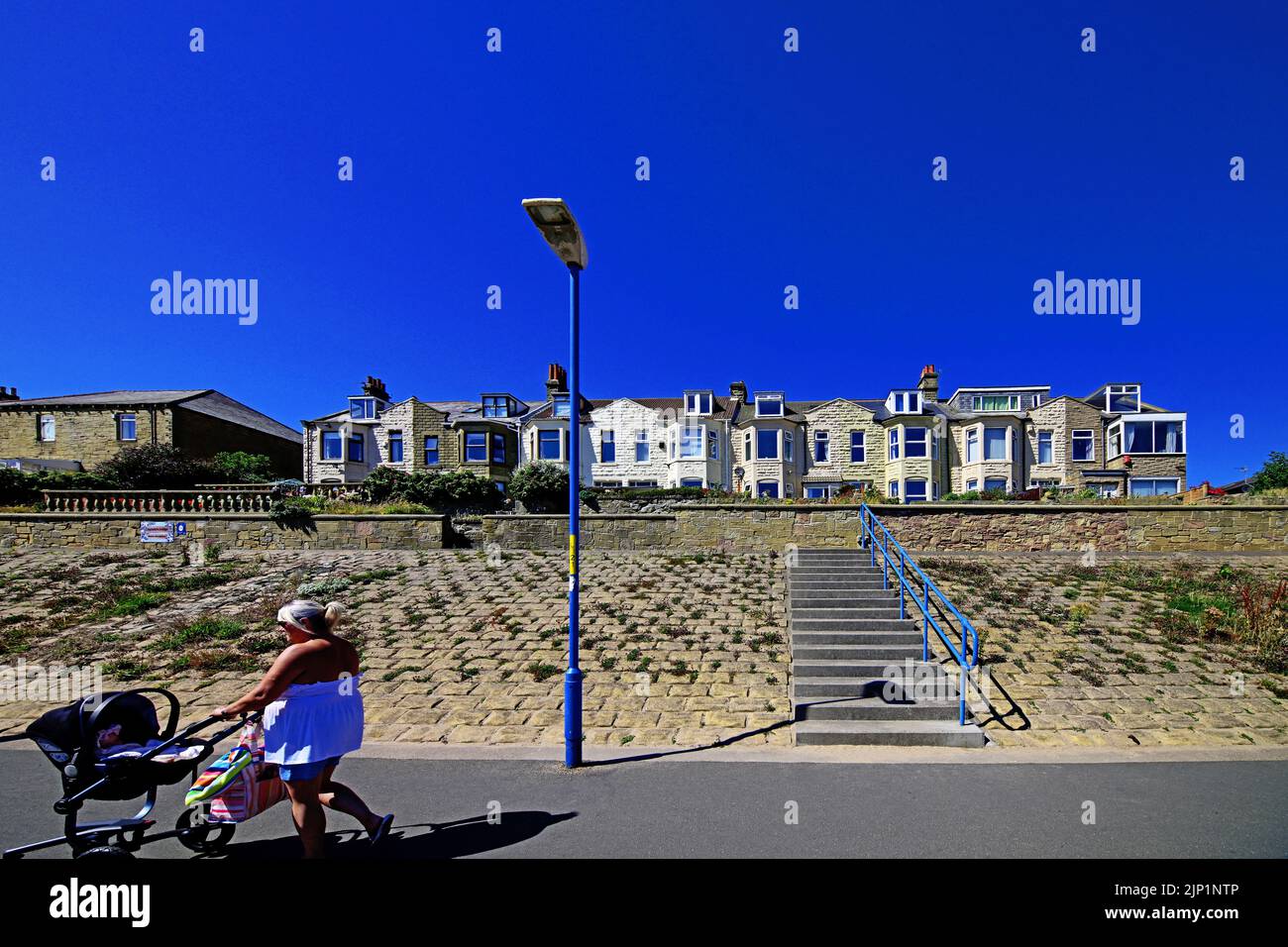 Newbiggin by the sea Northumberland beautiful seaside houses and places to stay on the long promenade with a deep blue sky Stock Photo