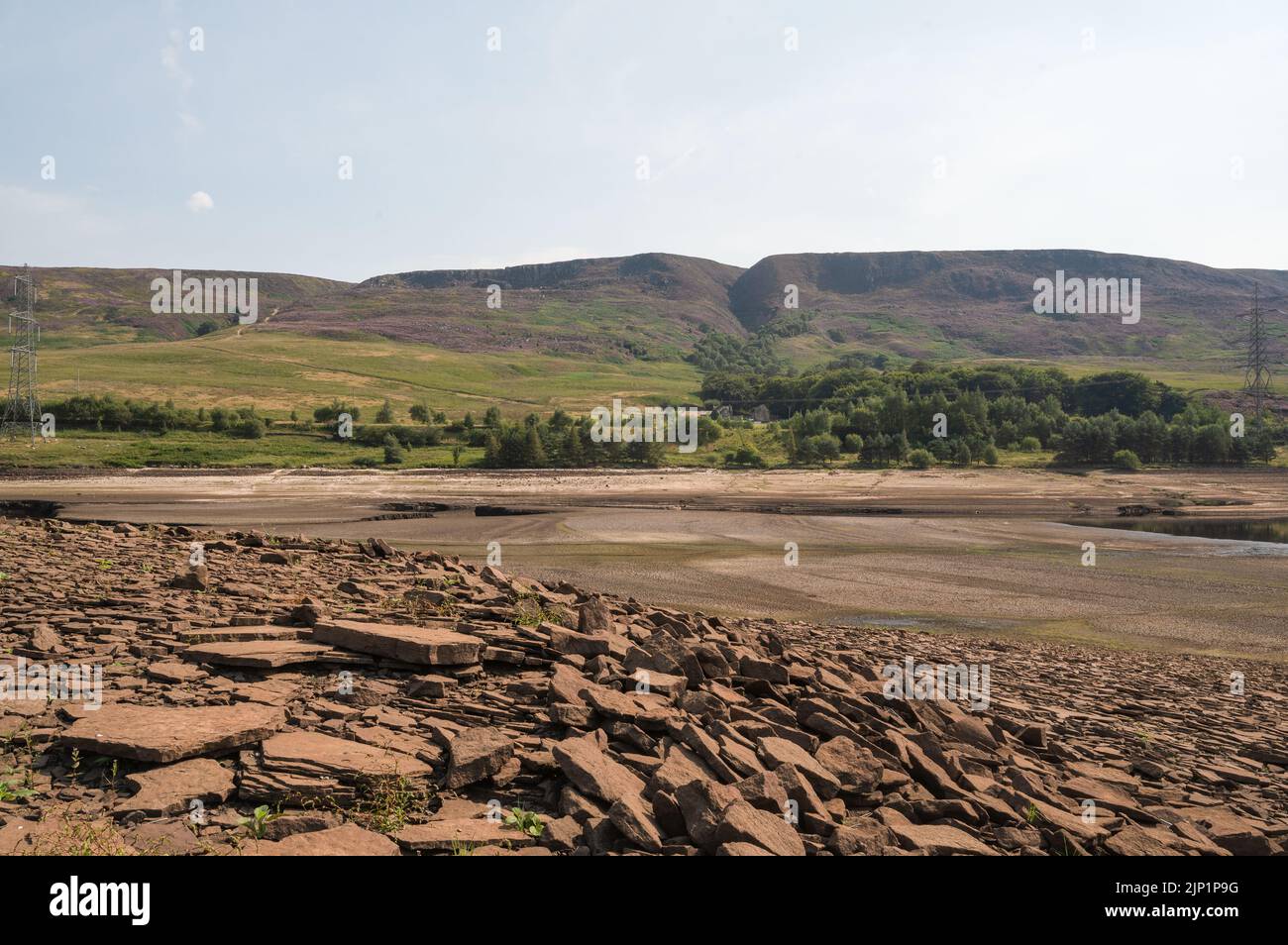 Exposed and dry earth and rocks of the reservoir bed at Woodhead Reservoir in Longdendale, Derbyshire, August heatwave, 2022 Stock Photo