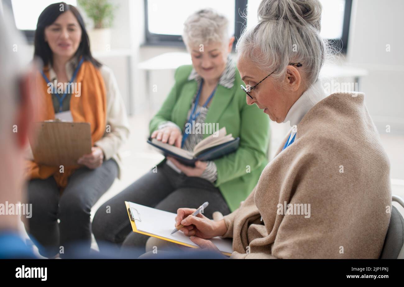 Group of seniors with singing books together at choir rehearsal. Stock Photo