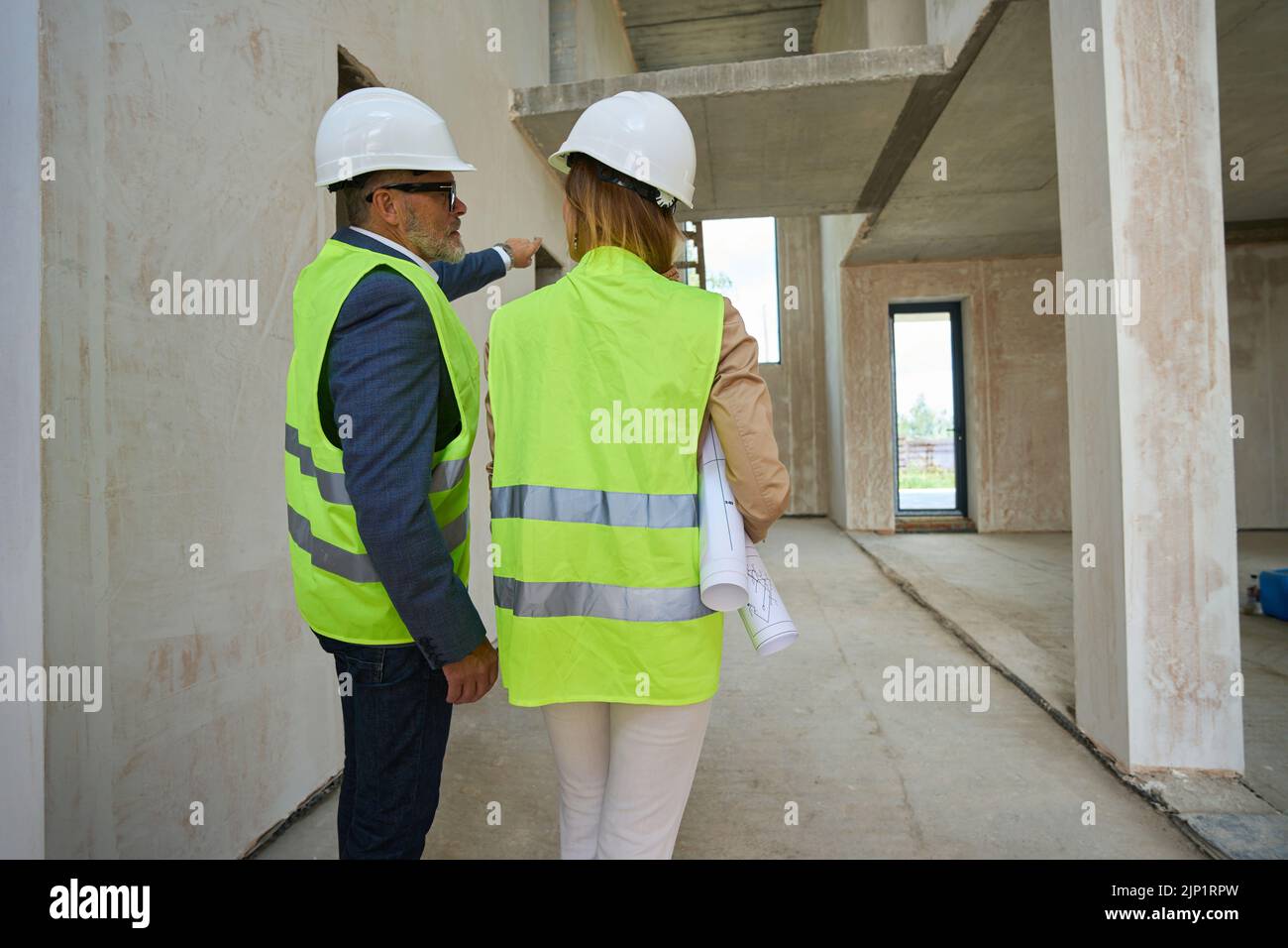 Realtor with drawings in his hands and foreman are talking Stock Photo