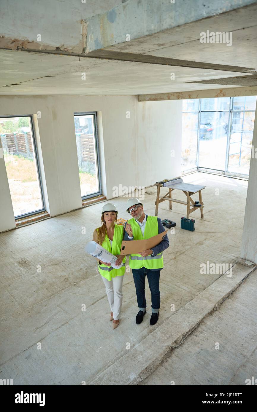 Realtor and the foreman, who holds an open folder Stock Photo Alamy