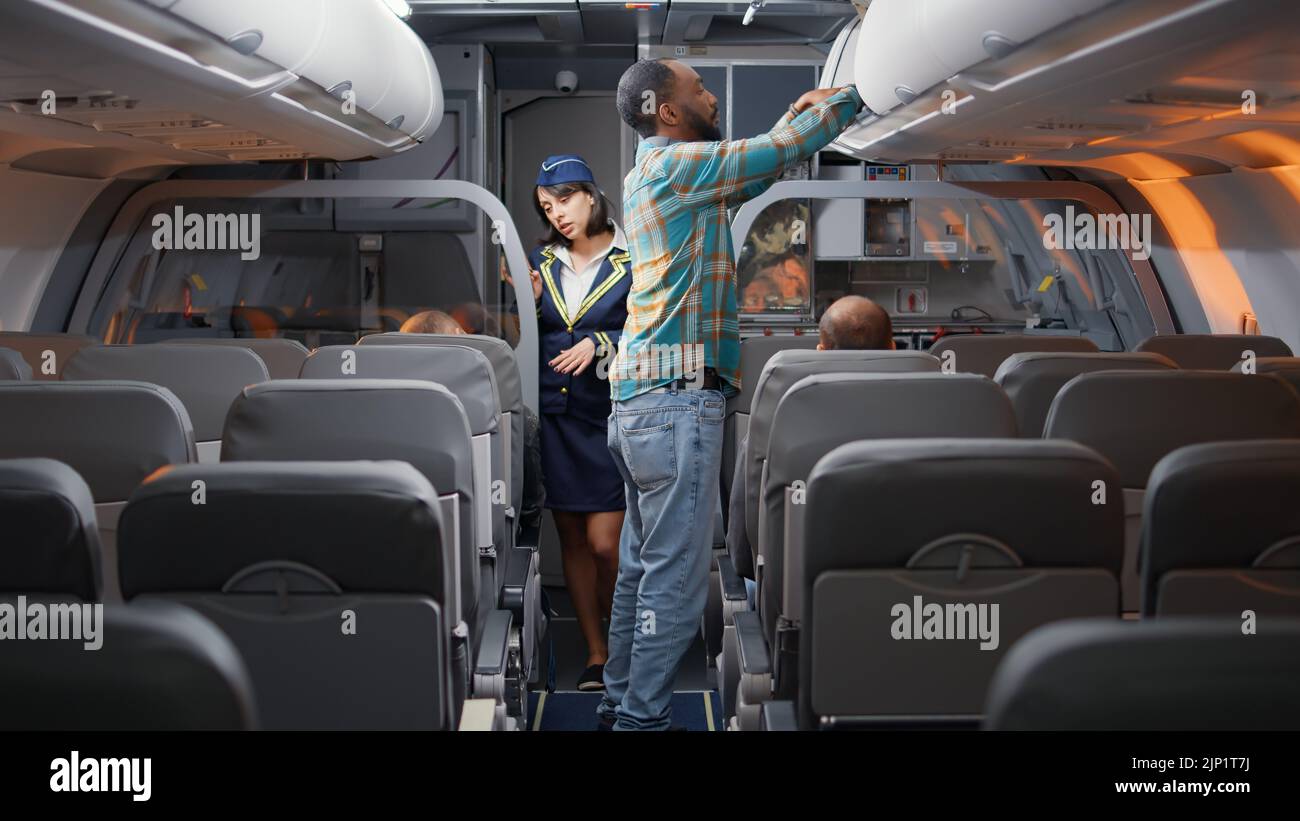 Diverse passengers boarding on airplane to fly in economy class, being