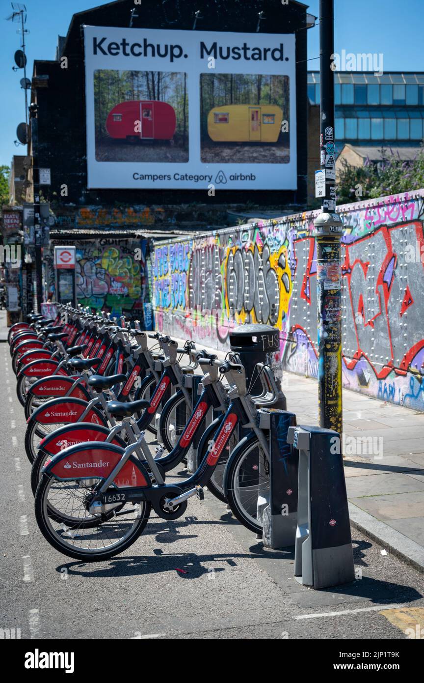 Santander hire bikes parked in a cycle rack in Brick Lane London Uk Stock Photo