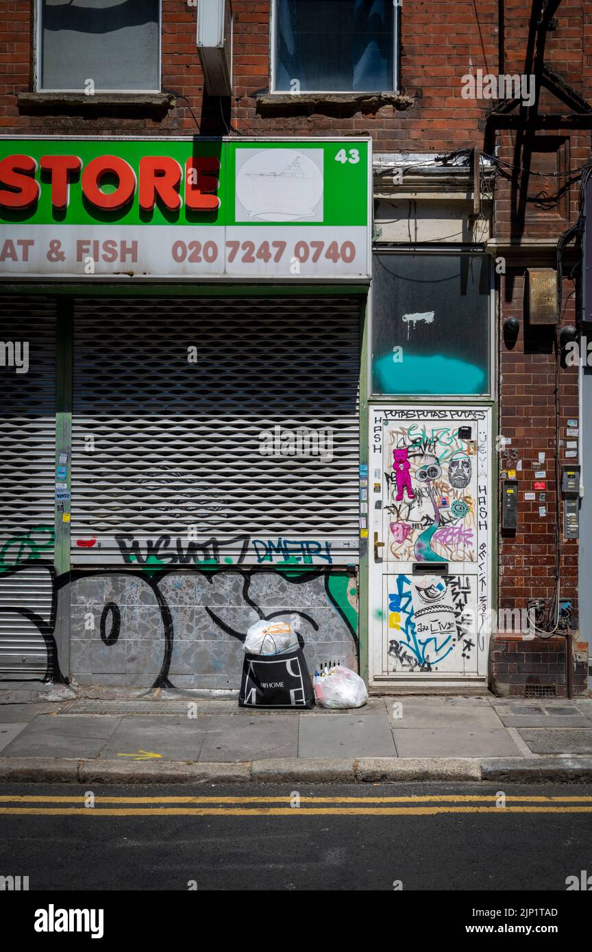 Grafitti on a wall and shop shutters in the Brick Lane area of London UK Stock Photo