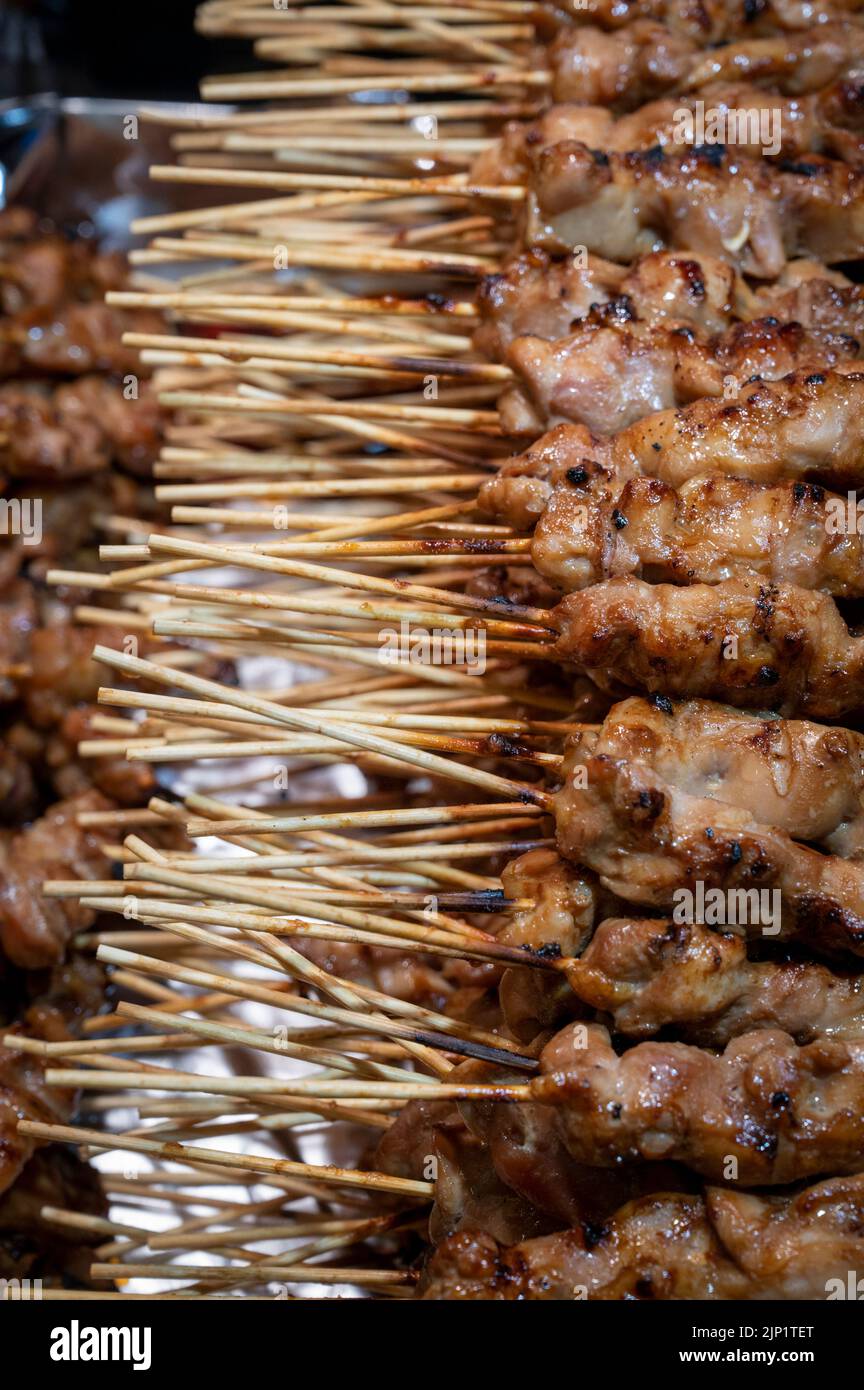 Chicken being grilled on wooden skewers Stock Photo