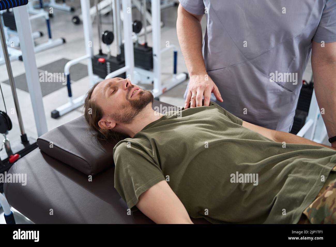 Soldier lies on a massage table in a rehabilitation center Stock Photo