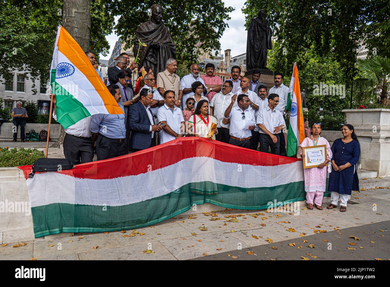 London, UK. 15th Aug, 2022. Members of the British Indian community stand in front  of the statue of of Mahatma Gandhi in Parliament Square o celebrate the 75th Anniversary of Independence of India on 15 August 1947  from the British Raj. Credit. Credit: amer ghazzal/Alamy Live News Stock Photo