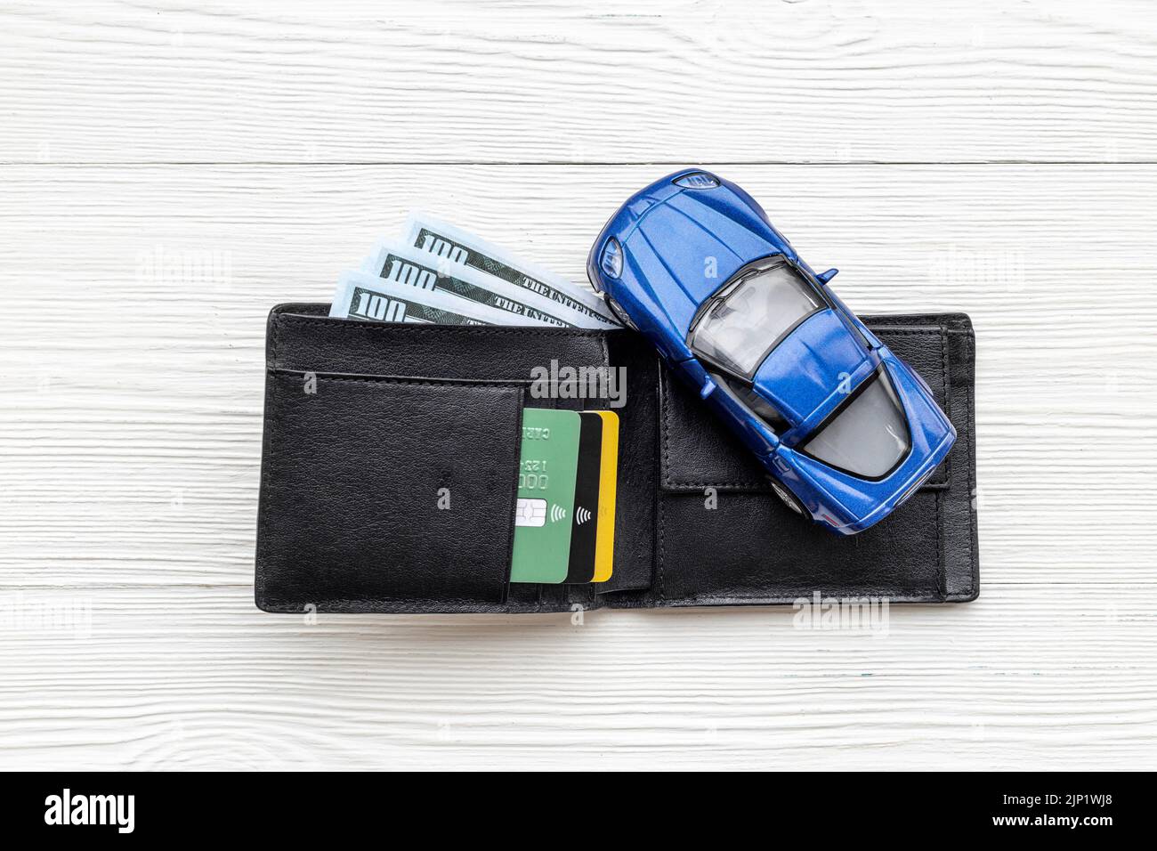 Purchase or rent a car concept. Toy car with wallet and money cash