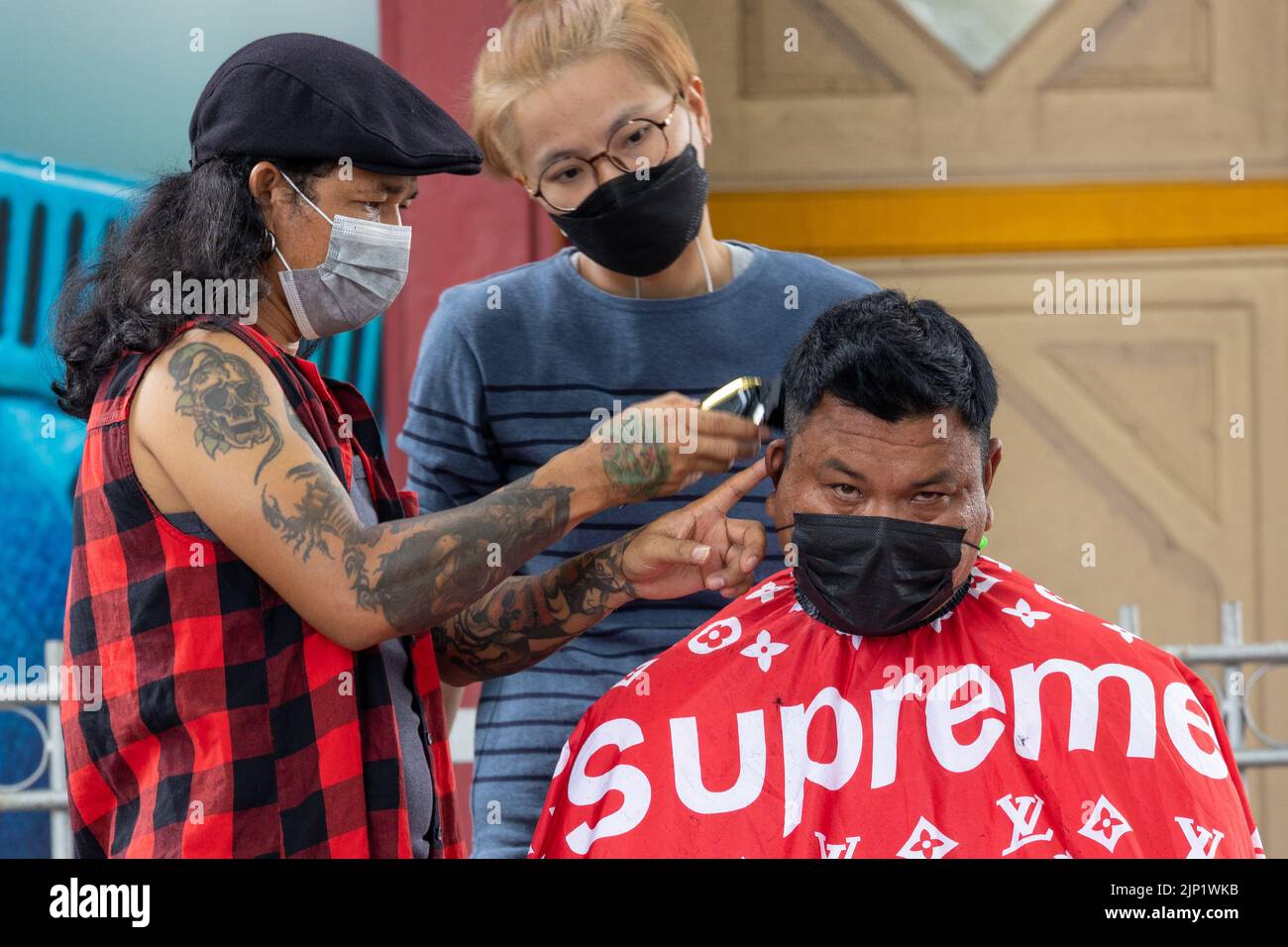 HUA HIN, THAILAND - 23 MARCH 2022 : A man having an outdoor haircut in the street near the train station. Stock Photo