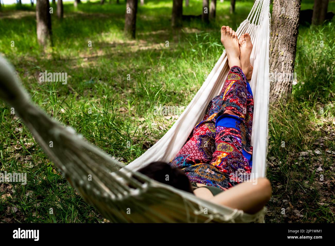 Young women relaxing in the forest laying on hammock Stock Photo - Alamy
