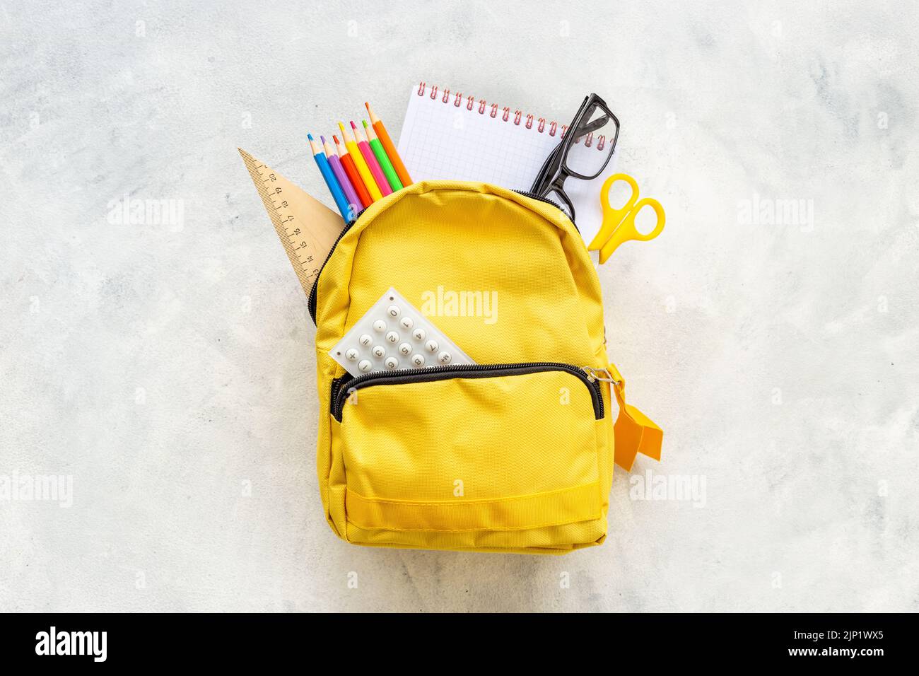 School bag with with colorful school items, top view Stock Photo