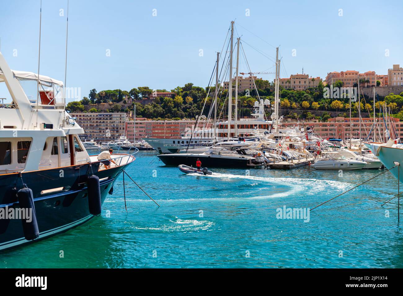 Monte Carlo, Monaco - August 15, 2018: Pleasure yacht with crew and yachts are moored in Port Hercule of Monte Carlo Stock Photo