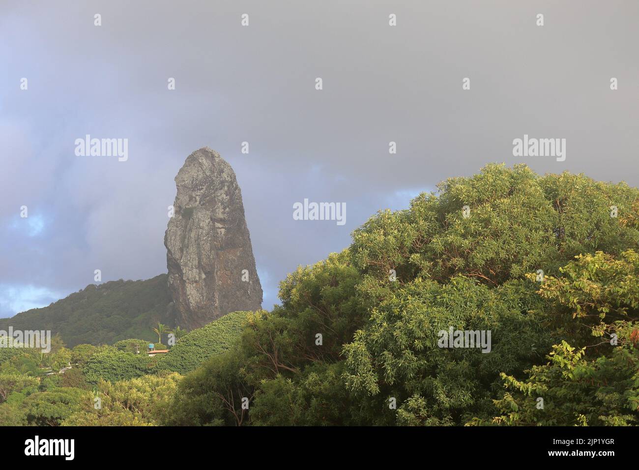 Morro do Pico rock under grey cloud at Fernando de Noronha archipelago, Brazil. Stock Photo