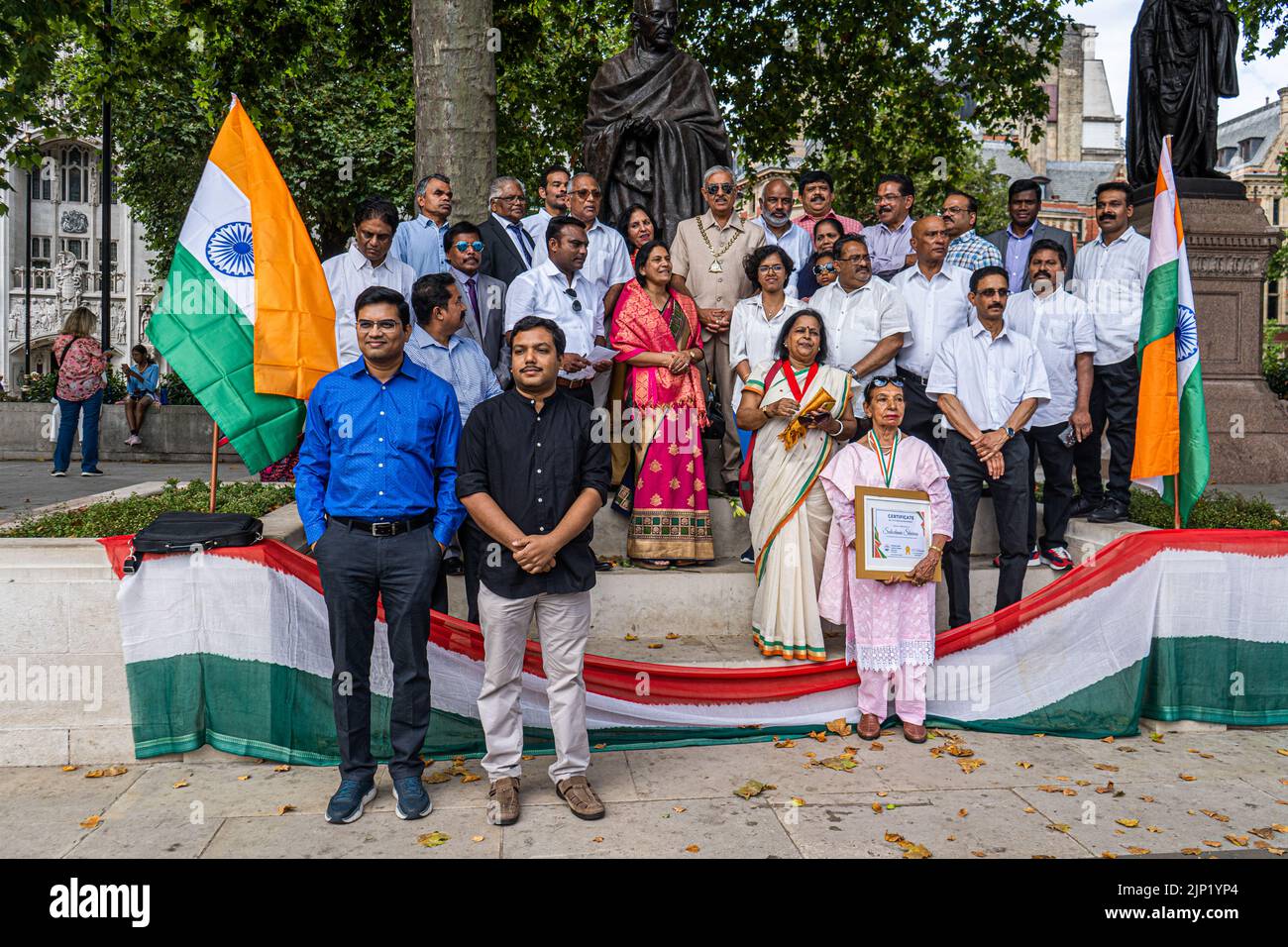 London, UK. 15th Aug, 2022. Members of the British Indian community stand in front the statue of of Mahatma Gandhi i in Parliament Square to celebrate the 75th Anniversary of Independence of India on 15 August 1947  from the British Raj. Credit. Credit: amer ghazzal/Alamy Live News Stock Photo