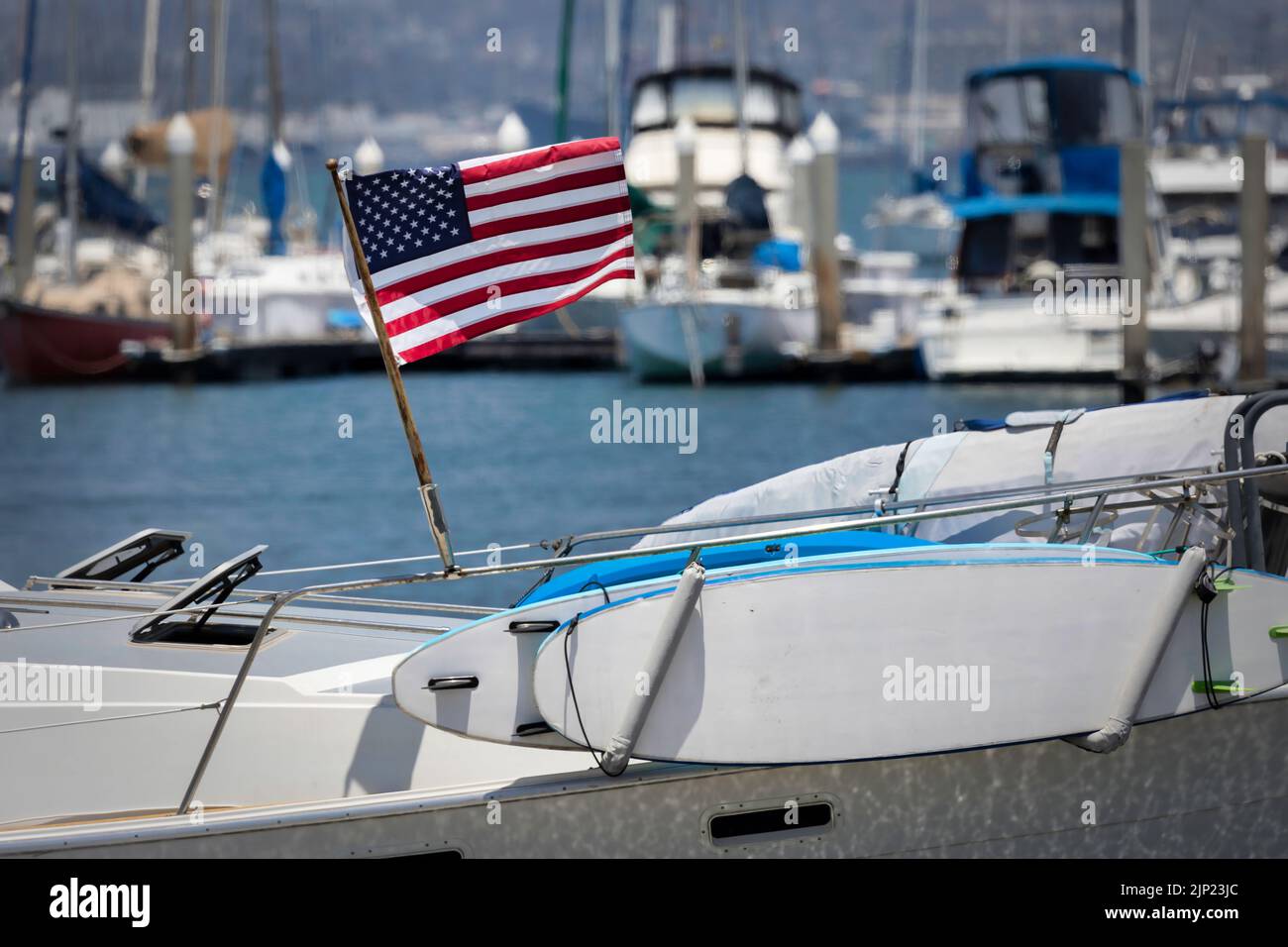 An American flag blows in the wind on a sailboat at Glorietta Bay in Coronado, California. Stock Photo