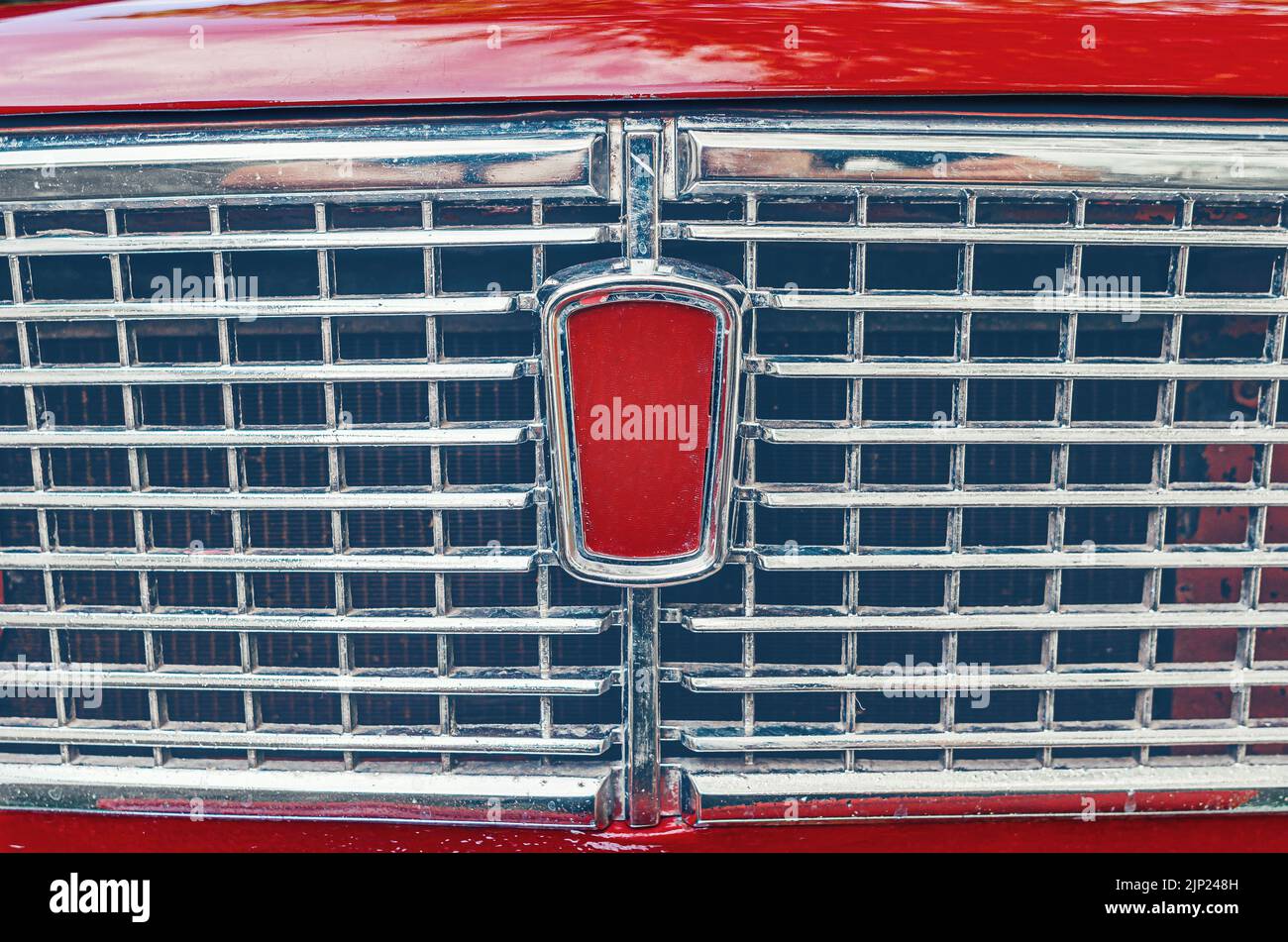 Сlose-up photo of front grille of bright red Soviet retro car. The front of old red Lada car. Stock Photo