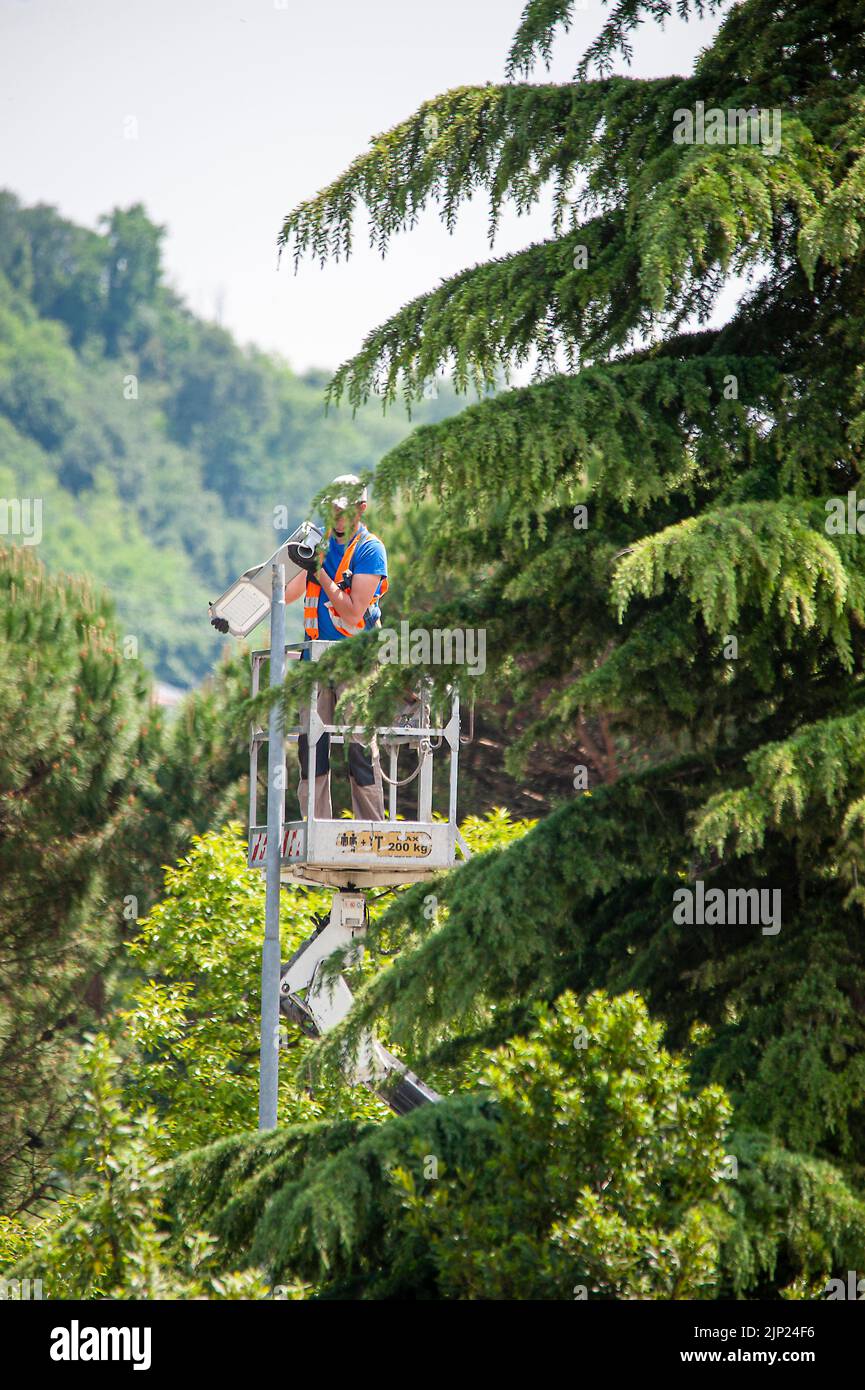 20 may 2020 Valdagno, Italy: Lamp post updating works of street lamps, replacement of lights with led bulbs, for better energy efficiency. The man in Stock Photo