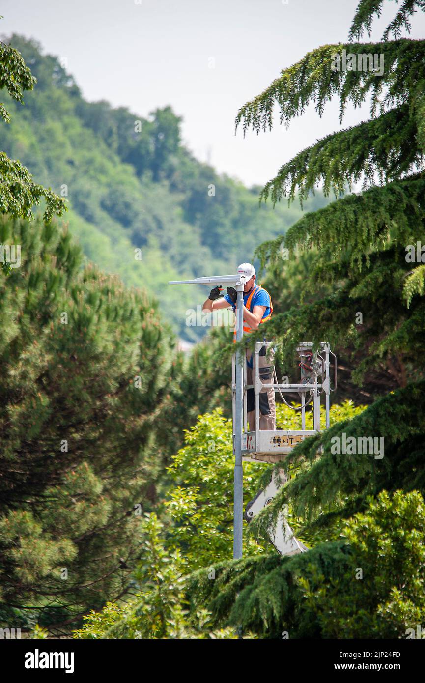 20 may 2020 Valdagno, Italy: Lamp post updating works of street lamps, replacement of lights with led bulbs, for better energy efficiency. The man in Stock Photo