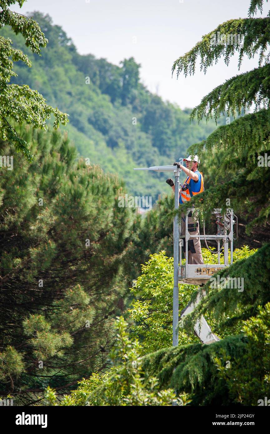 20 may 2020 Valdagno, Italy: Lamp post updating works of street lamps, replacement of lights with led bulbs, for better energy efficiency. The man in Stock Photo