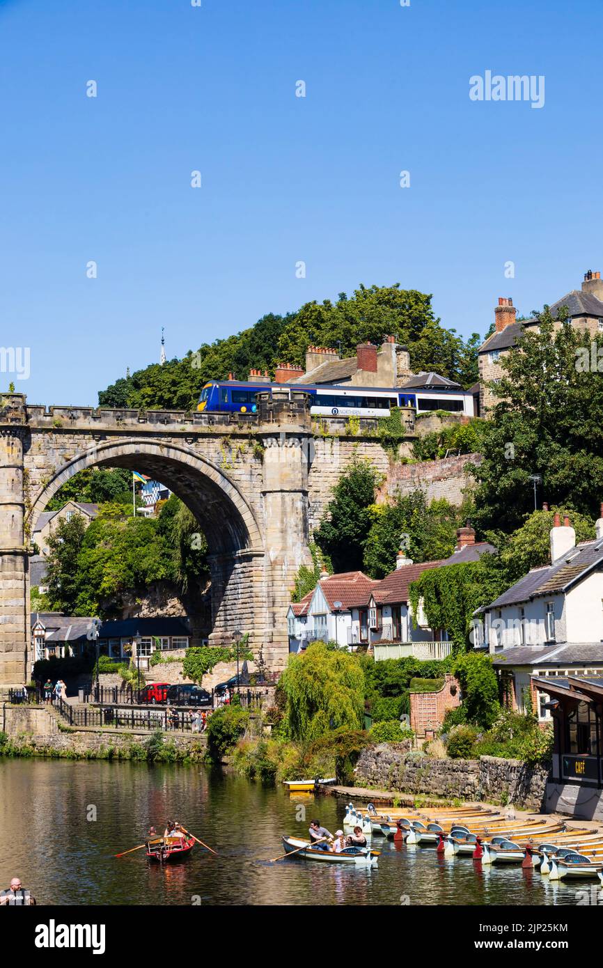 The Railway viaduct over the River Nidd, Knaresborough, North Yorkshire, England. Hot summer day with people on boats in the river. Stock Photo