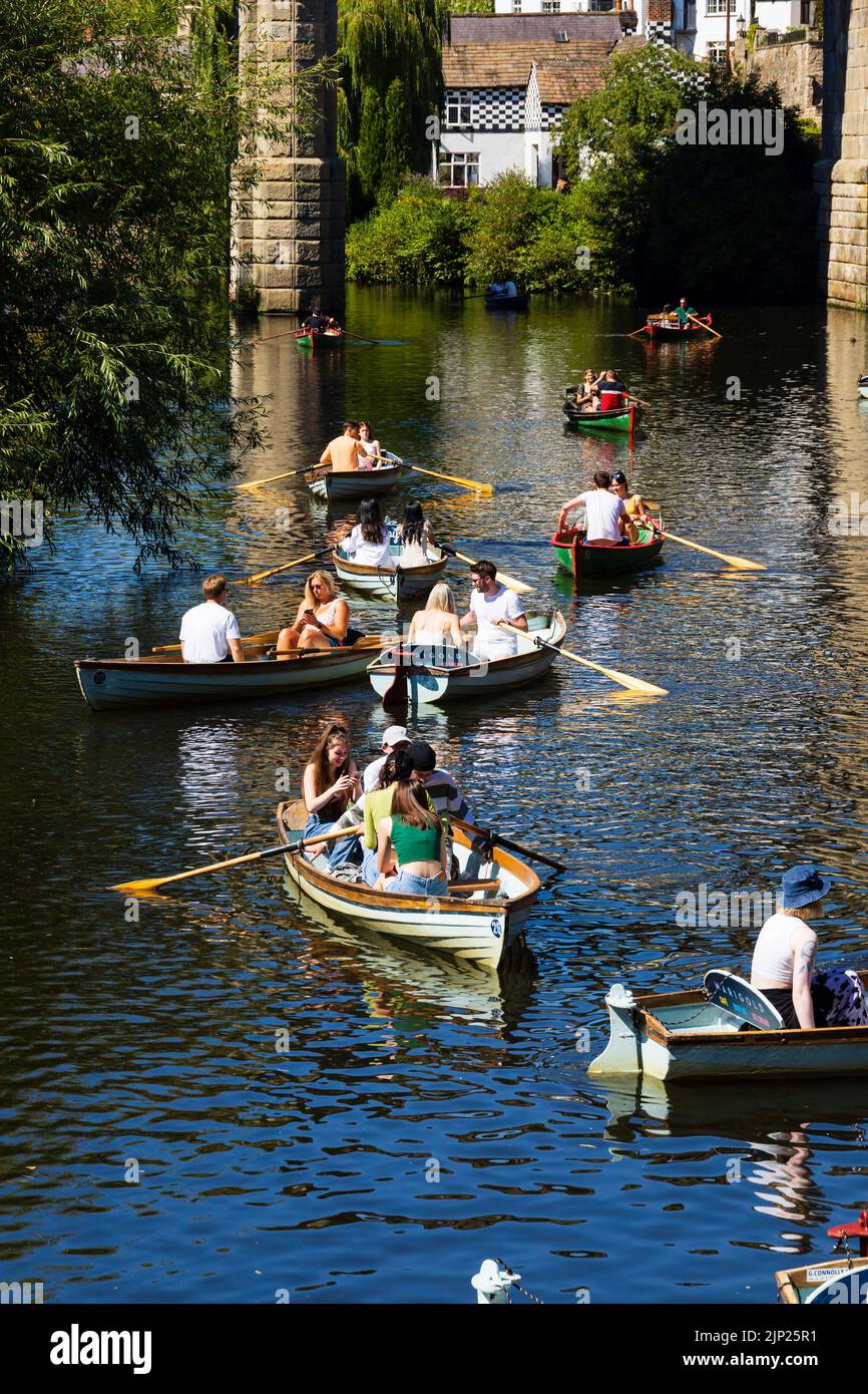 Daytrippers and tourists take to the water on one of the hottest days of the year. The Railway viaduct over the River Nidd, Knaresborough, North Yorksh Stock Photo