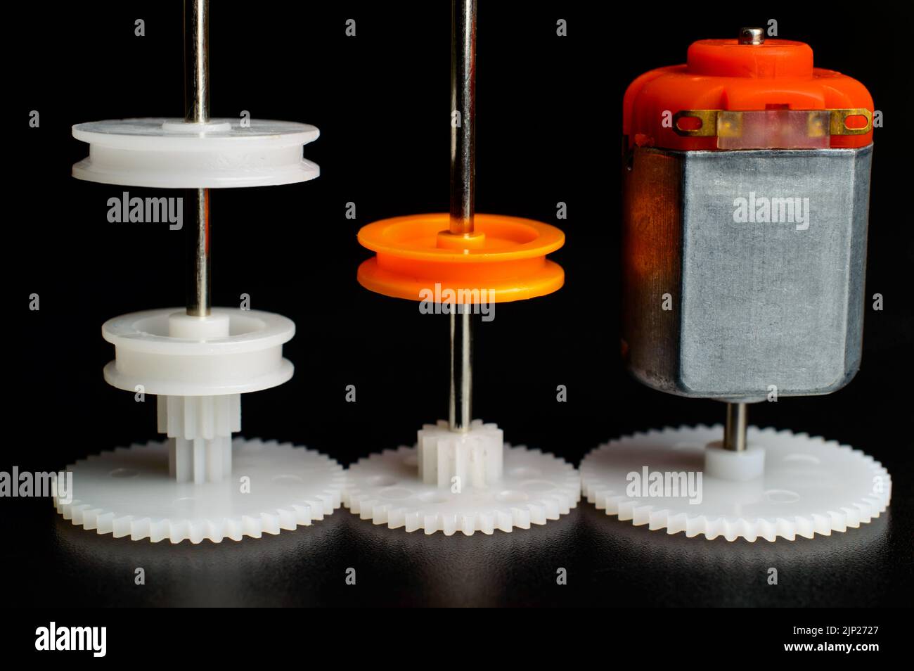 Direct current electric motor with white gear attached to it shaft on a