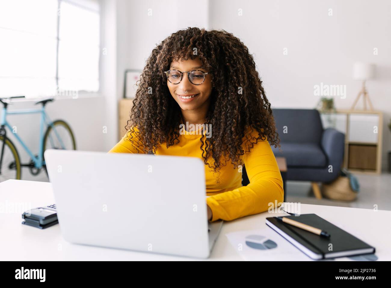 Young latin woman working on laptop at home Stock Photo