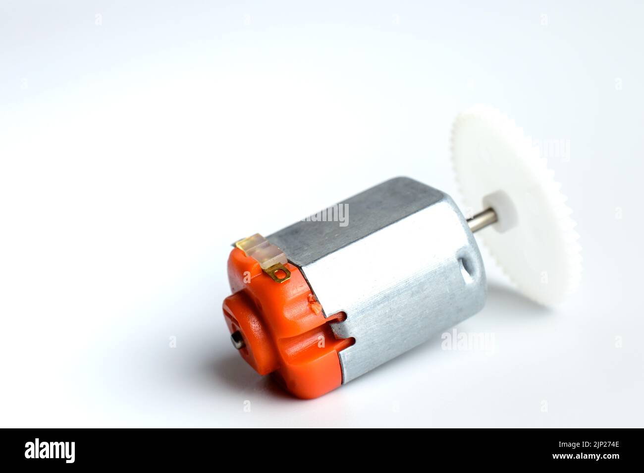 Direct current electric motor with white gear attached to it shaft on a