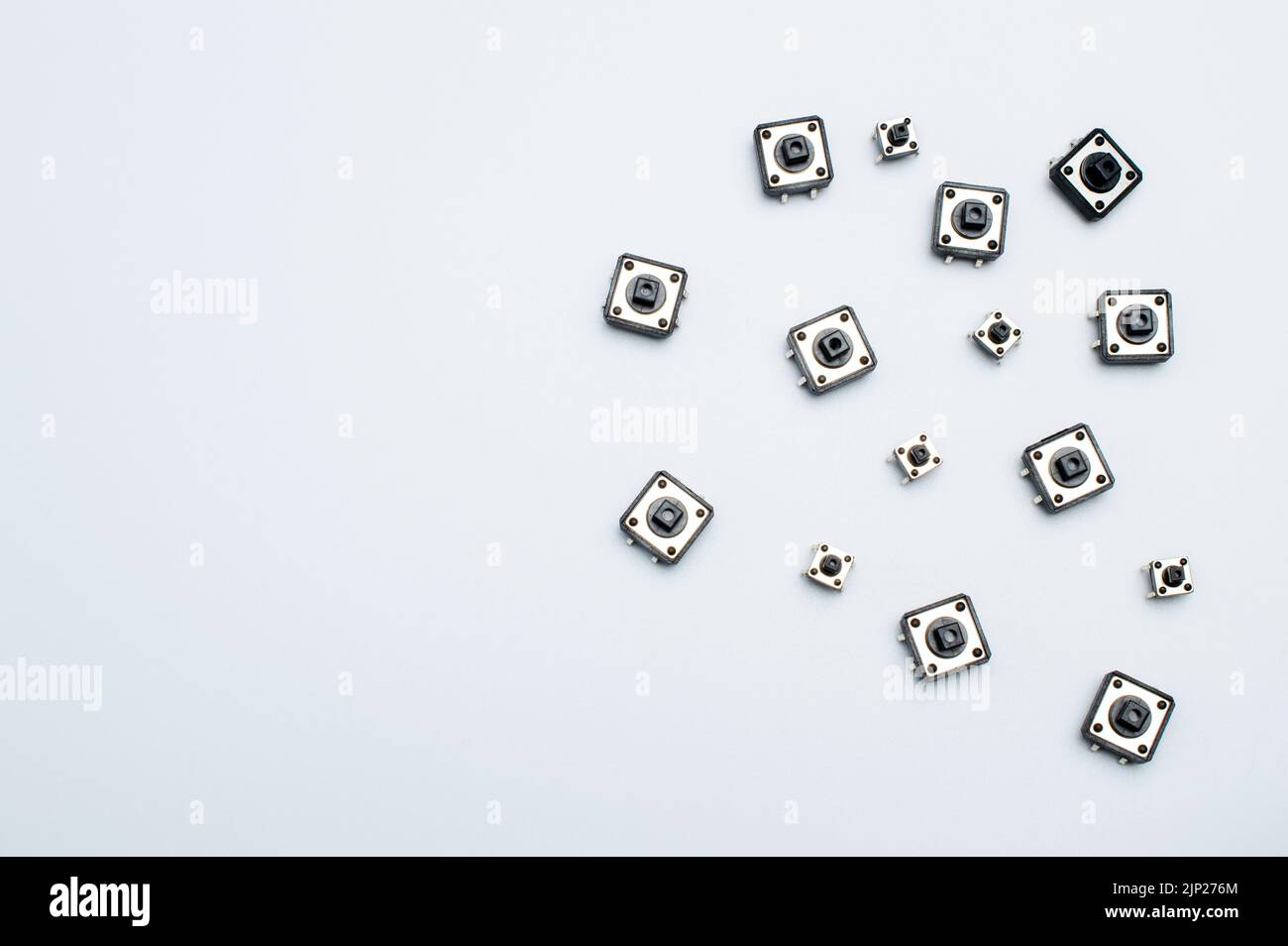 Small black buttons. Starting impulse. White background. Macro photo. Space for text Stock Photo