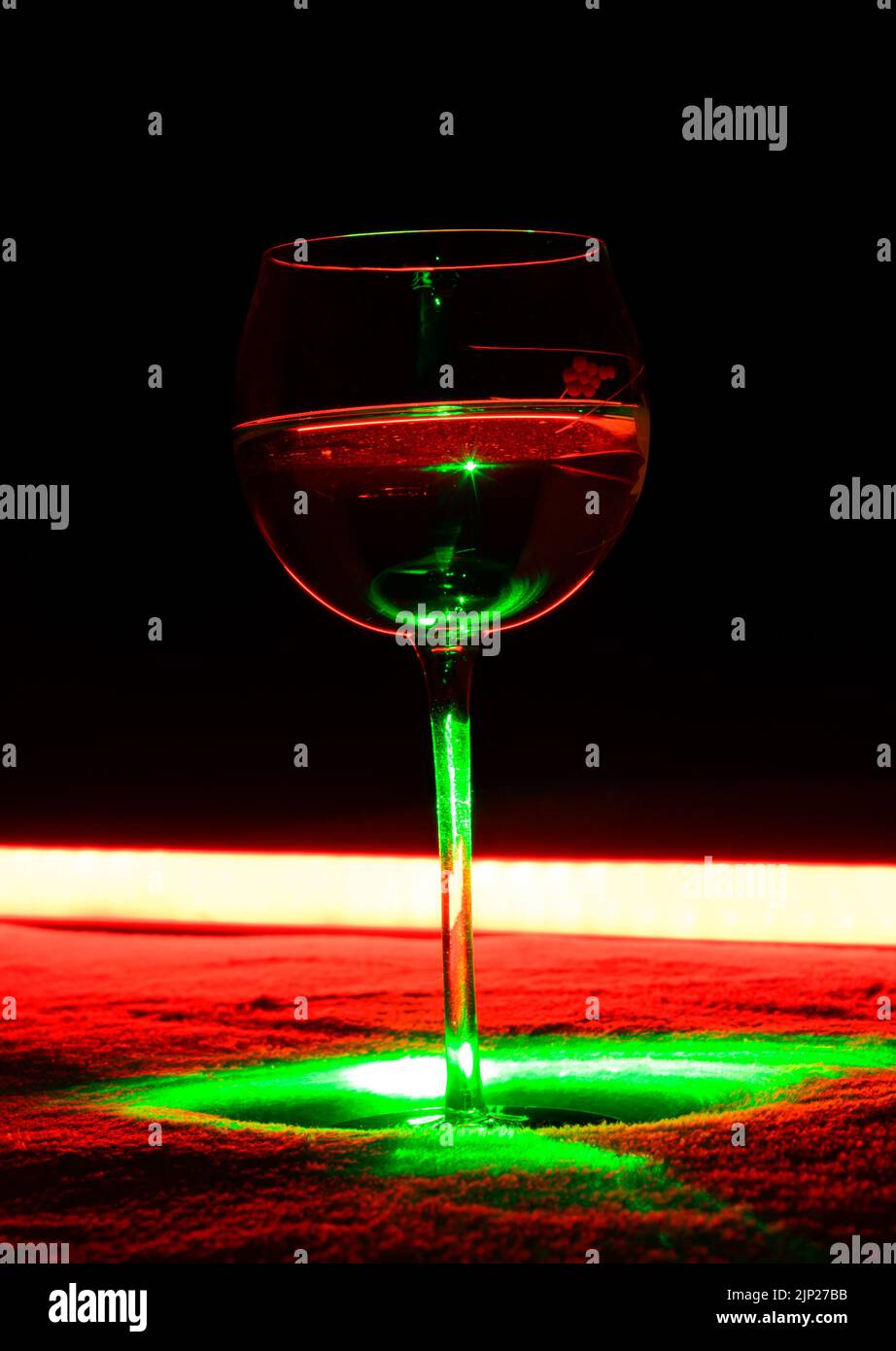 One Glass of an Alcoholic Cocktail on Dark Background with red backlight. Very dangerous fire cocktail - close up photo. Background picture. Stock Photo