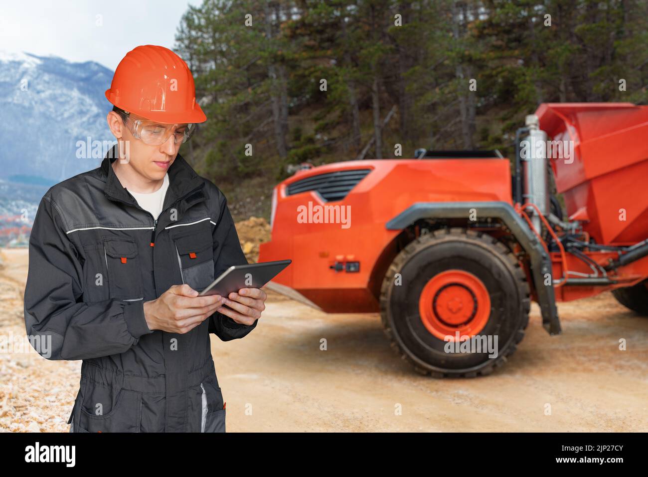Engineer programs autonomous mining truck using digital tablet Stock Photo