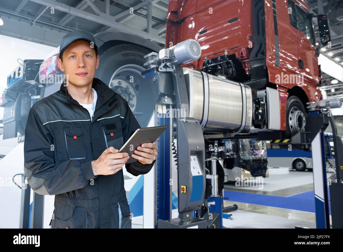Serviceman with tablet on the background of the truck in the garage Stock Photo