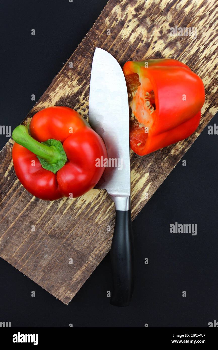 Knife cut the red pepper in kitchen on wooden board Stock Photo
