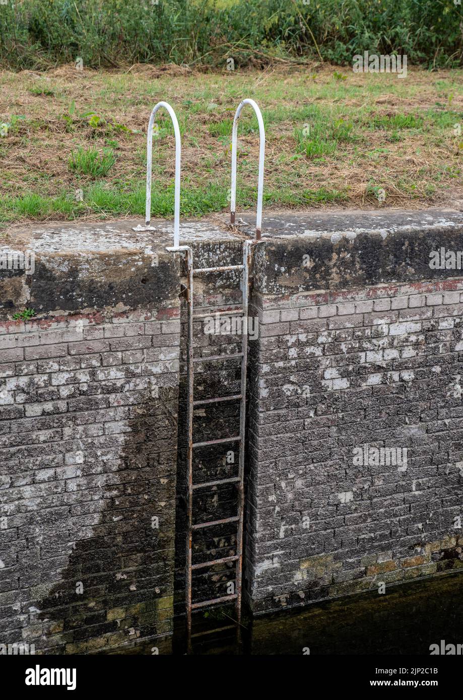 Canal lock side wall ladder, metal set into a brick wall. Stock Photo