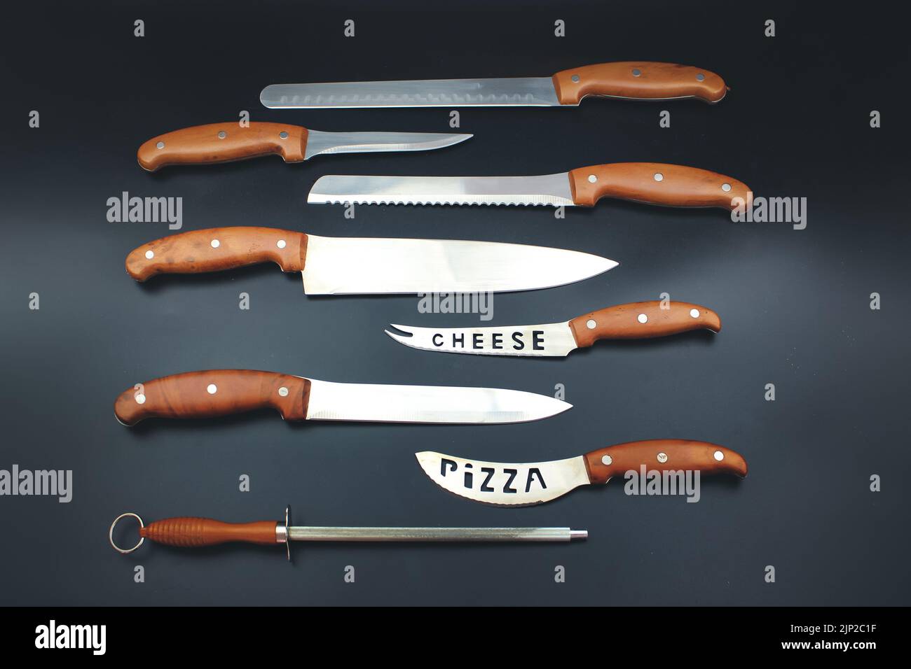 Quality Kitchen Knives. Set of various kitchen knives arranged on black, top view. Stock Photo