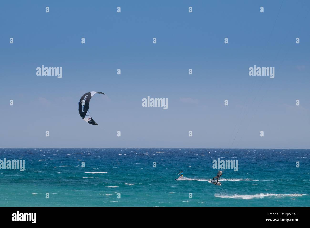 Men kitesurfing and jumping in the Beach of Agiokampos, Greece Stock Photo