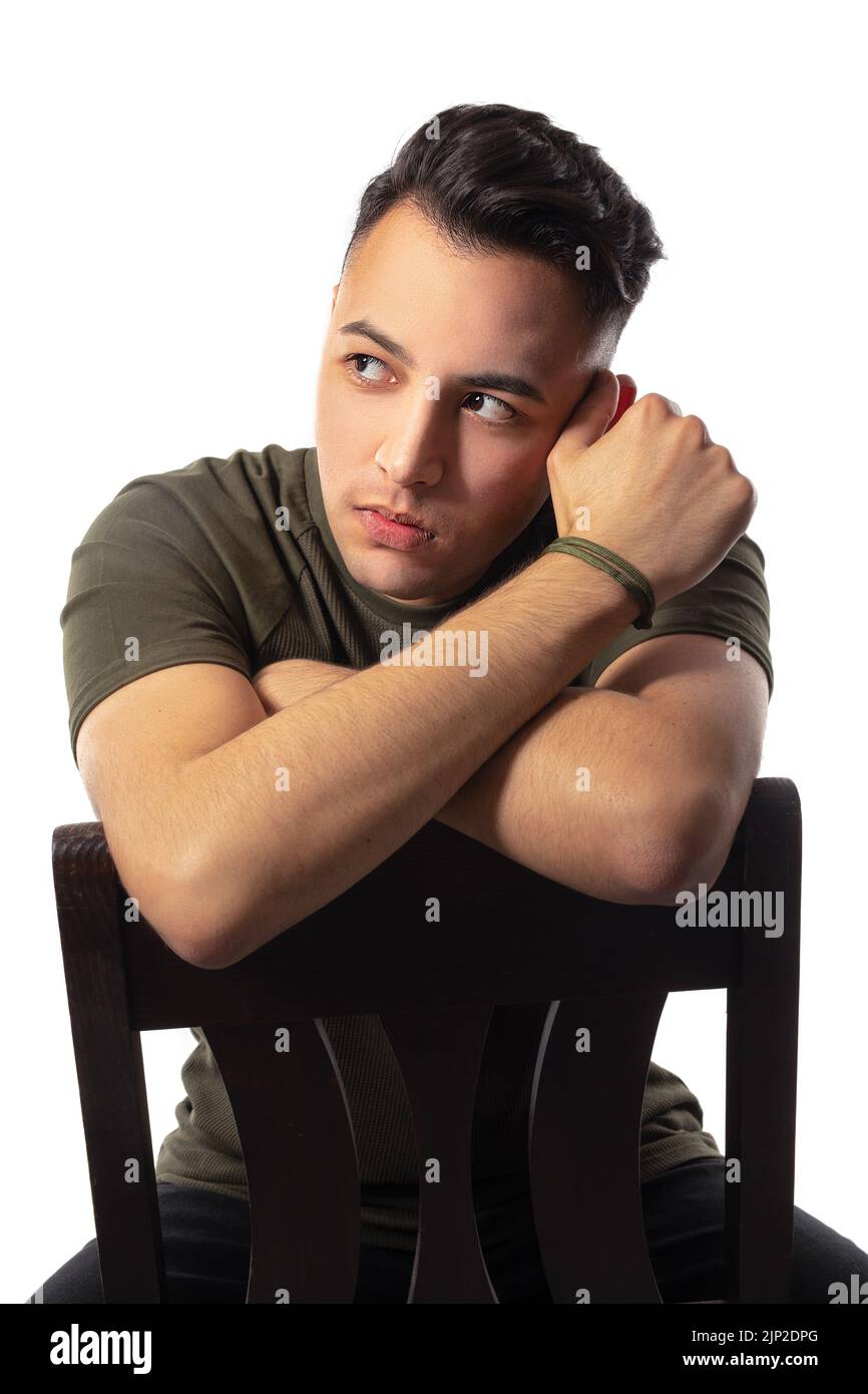 A handsome male sitting on a chair in a studio Stock Photo