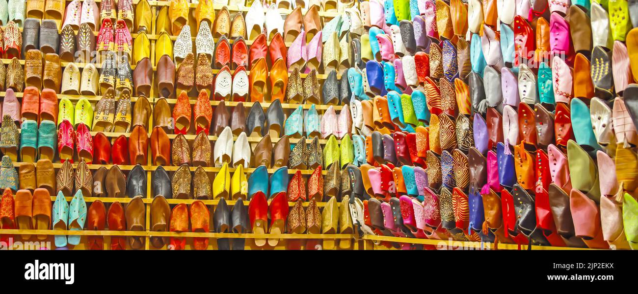 Store shelf with choice of many colorful typical oriental moroccan babouches leather slippers - Morocco Stock Photo