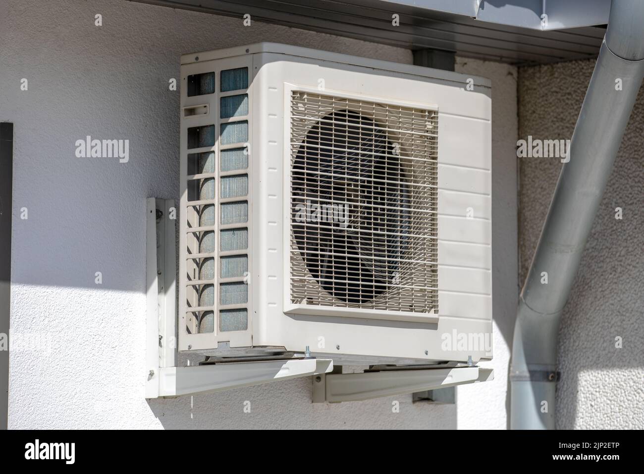 An old aged air conditioner machine outside mounted at wall Stock Photo