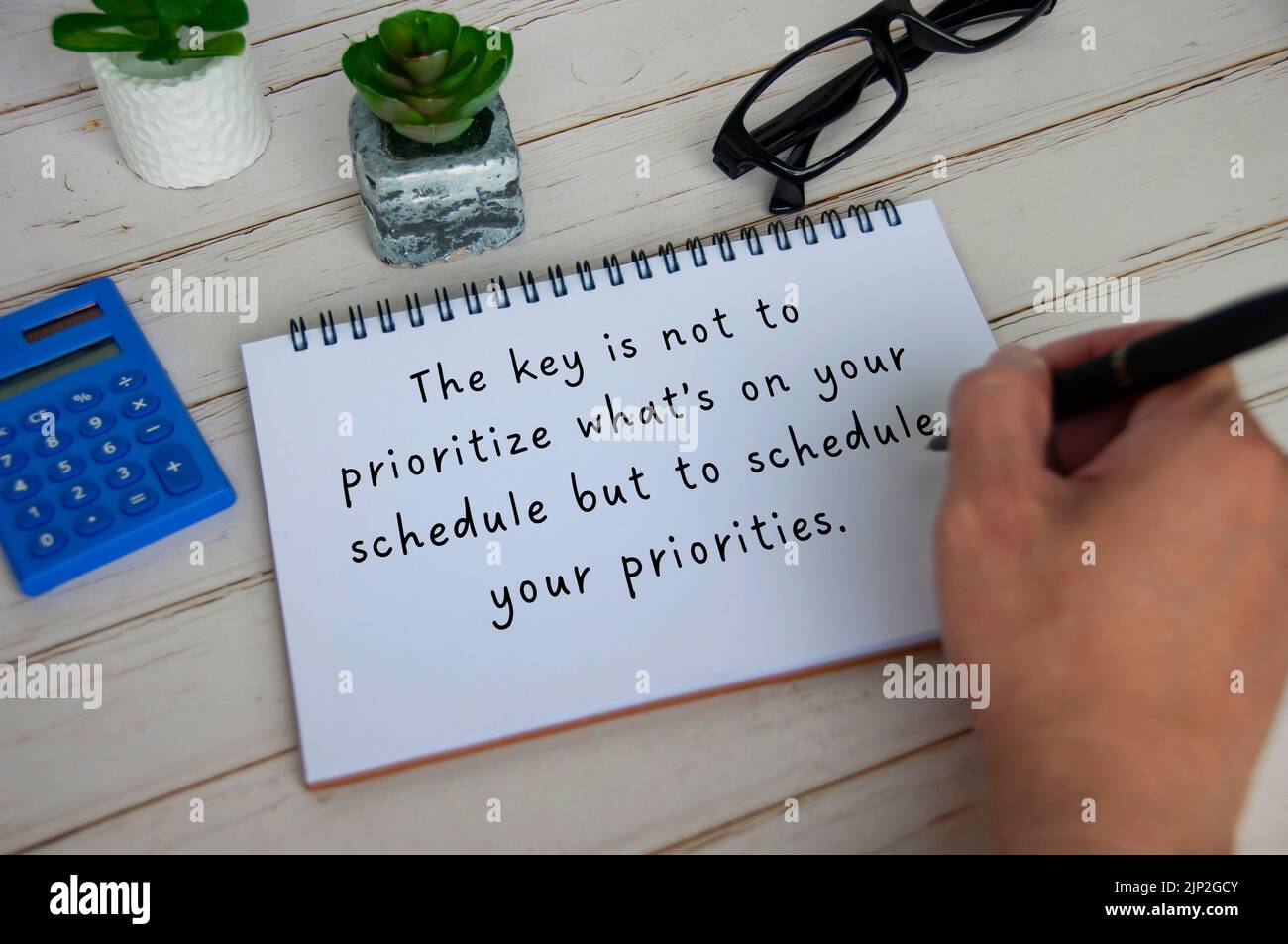 Inspirational quote text on white notepad about priorities and scheduling. Inspirational concept. Stock Photo