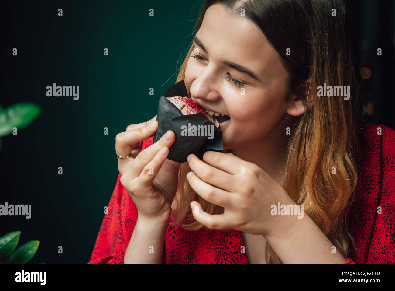 A young woman enjoys a raspberry muffin in a cafe Stock Photo - Alamy