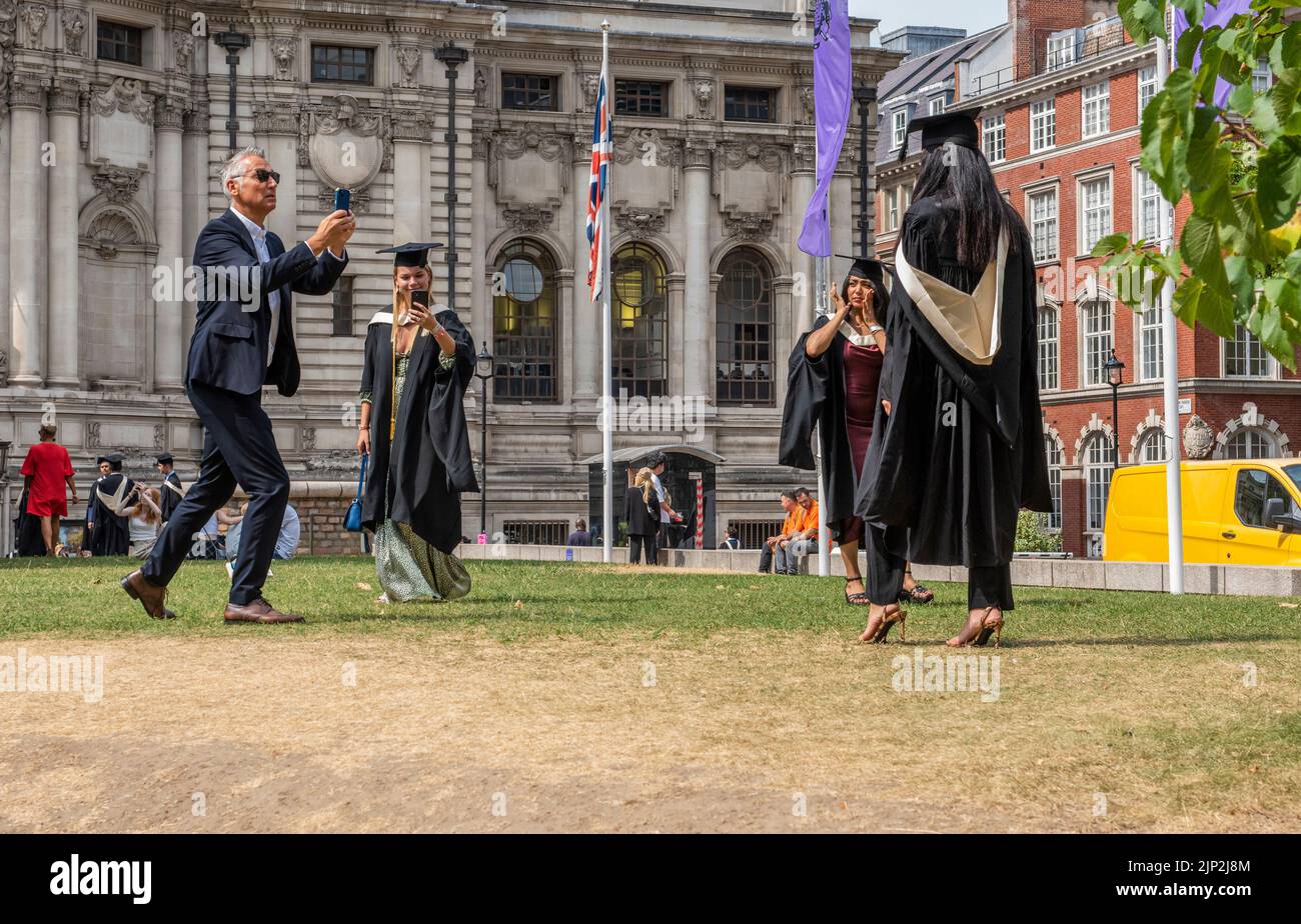 Westminster, London, UK. 15th Aug, 2022. Graduates posing for photographs on a scorched, brown patch of grass near Westminster Abbey, due to the current heatwave. Picture Credit: ernesto rogata/Alamy Live News Stock Photo