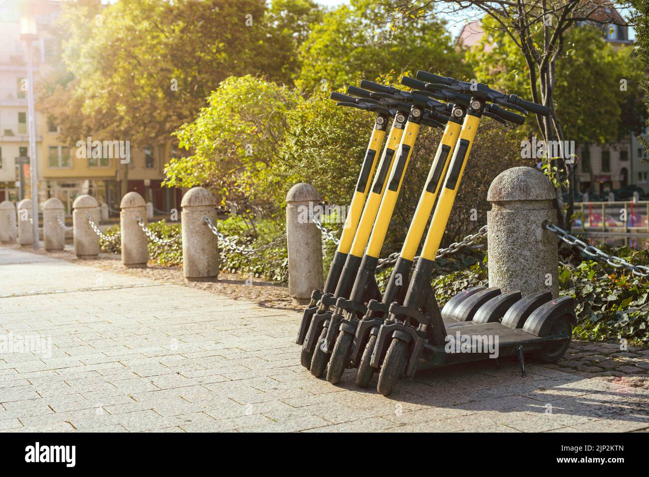Coseup of electric scooters standing on sidewalk ready to rent and use as transportation in city