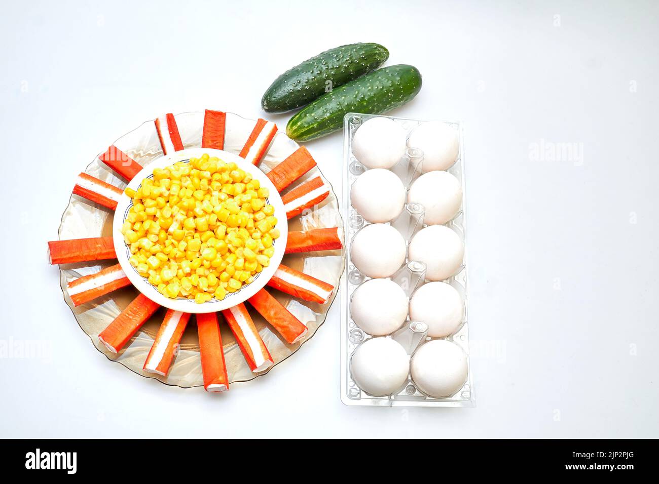 A set for a delicious healthy salad. Cucumbers, eggs, corn, crab sticks Stock Photo