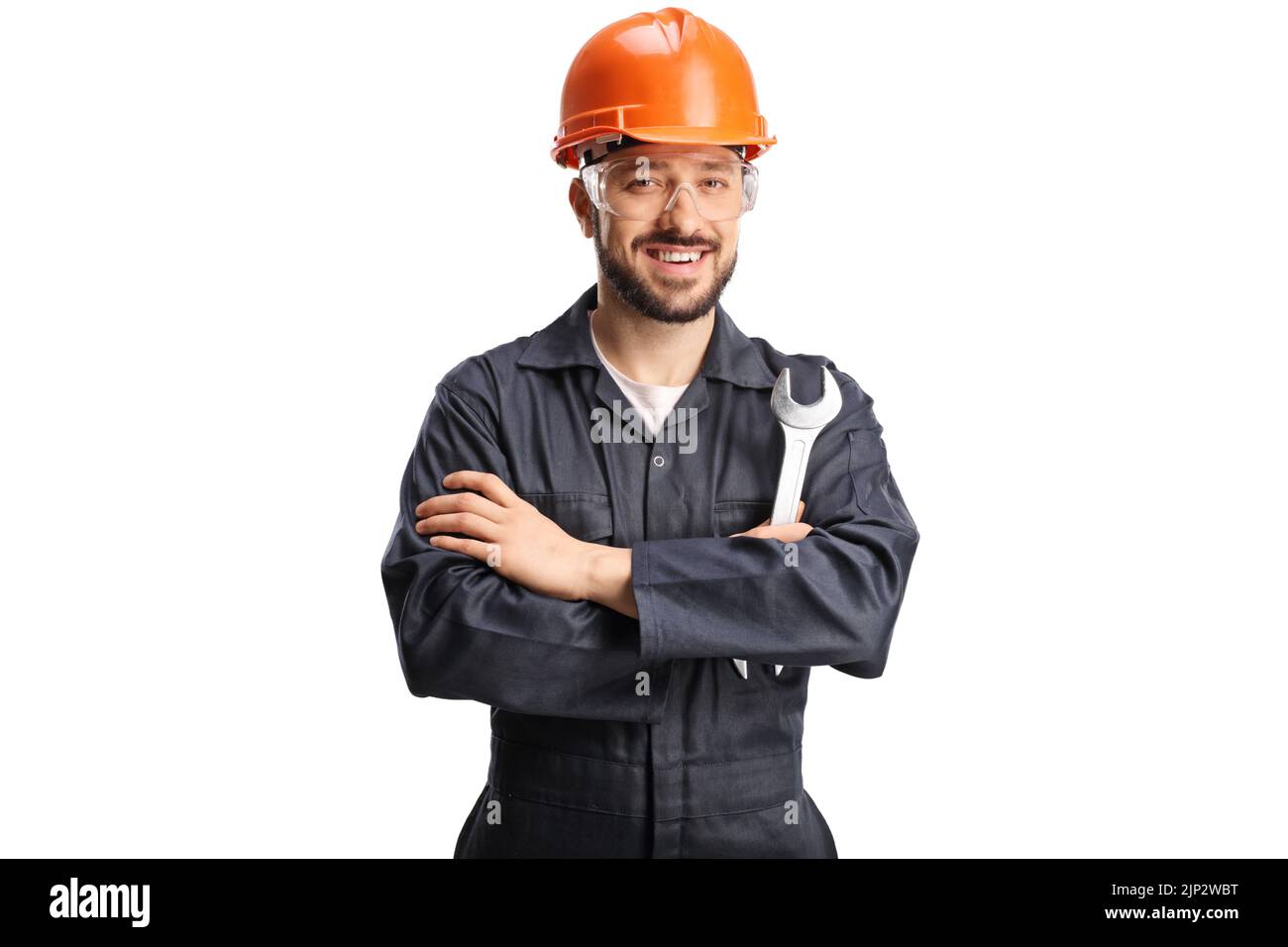 Smiling young worker with an orange hardhat holding a wrench isolated on white background Stock Photo