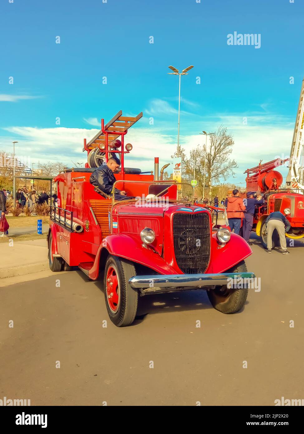 Avellaneda, Argentina - Jun 4, 2022: Old red 1936 Ford model 51 V8 fire truck pumper tanker. Front view. Grill. Ladder. Classic car show. Stock Photo