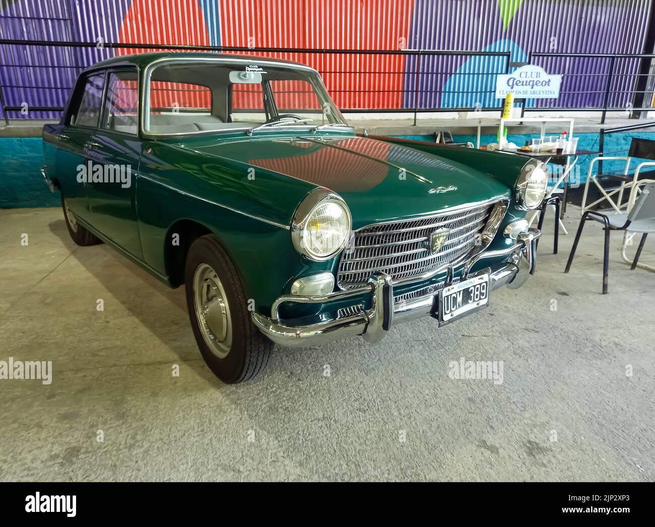 Old green popular Peugeot 404 sedan 1960 - 1975 in a warehouse yard. Front view. Grille. Expo Fierro 2022 classic car show. Copyspace. Stock Photo